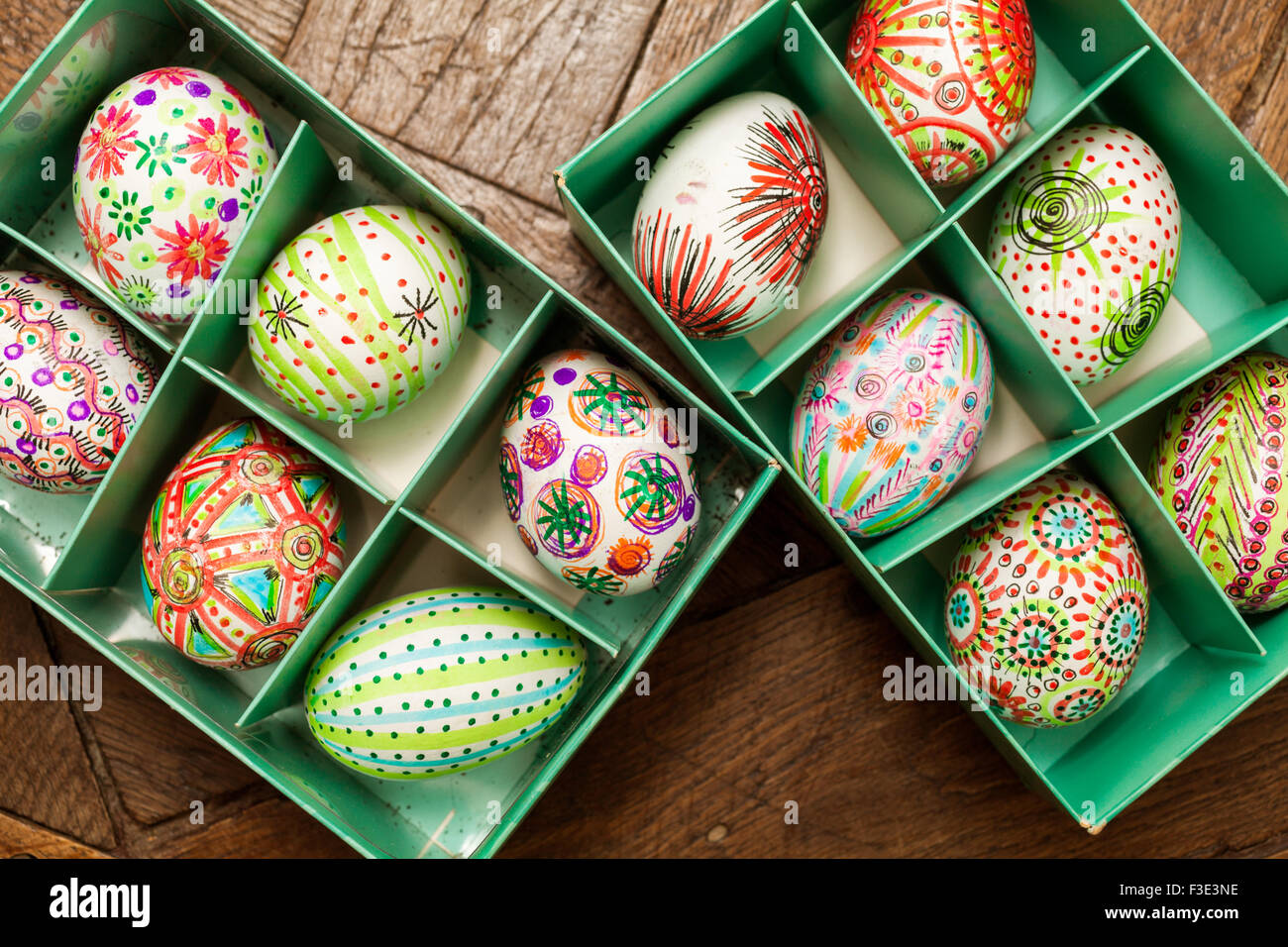 Hand painted colorful Easter eggs in green box on rustic wooden planks Stock Photo