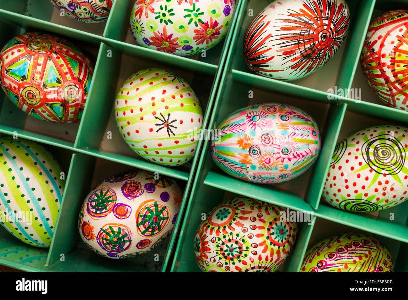Hand painted colorful Easter eggs in green box on rustic wooden planks Stock Photo