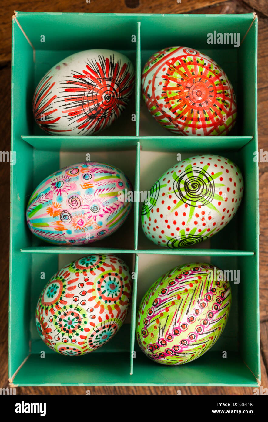 Hand painted colorful Easter eggs in green box on rustic wooden planks Stock Photo