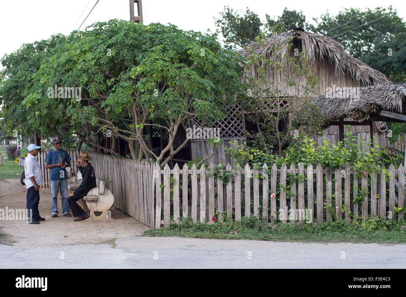 Three Cuban men socialising in front of a shop in Playa Larga on the island of the Republic of Cuba Stock Photo