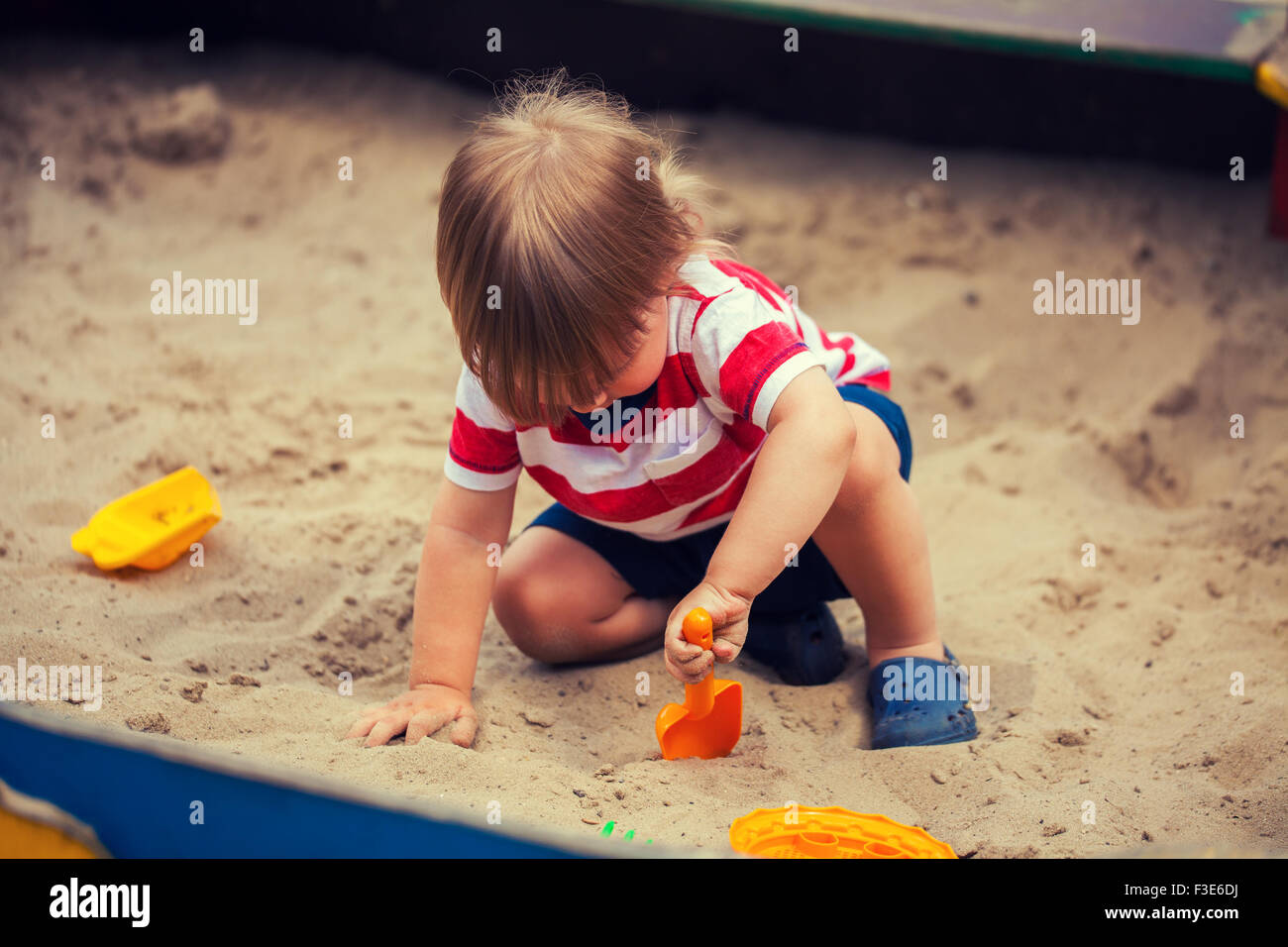 Little boy playing in sandbox Stock Photo
