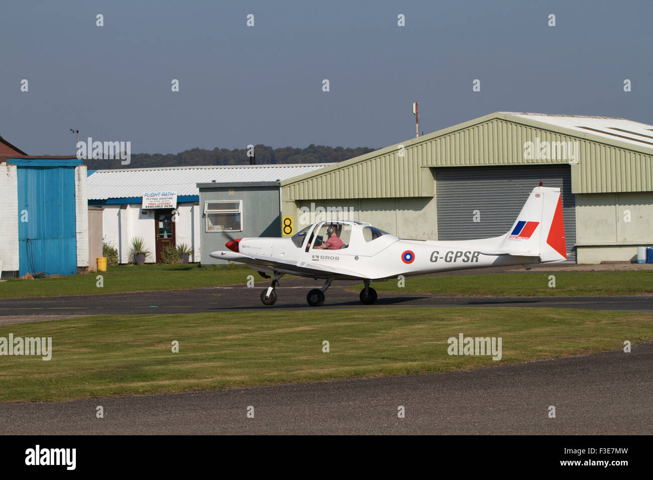 Single engined light aircraft taxiing near out buildings at Wolverhampton Airport. UK Stock Photo