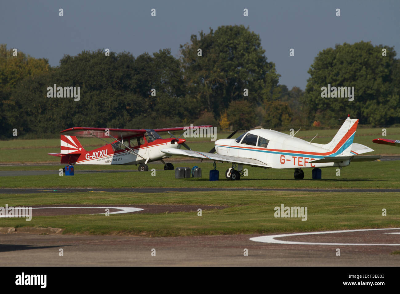 2x light aircraft parked on grass near runway. Wolverhampton Airport. UK Stock Photo