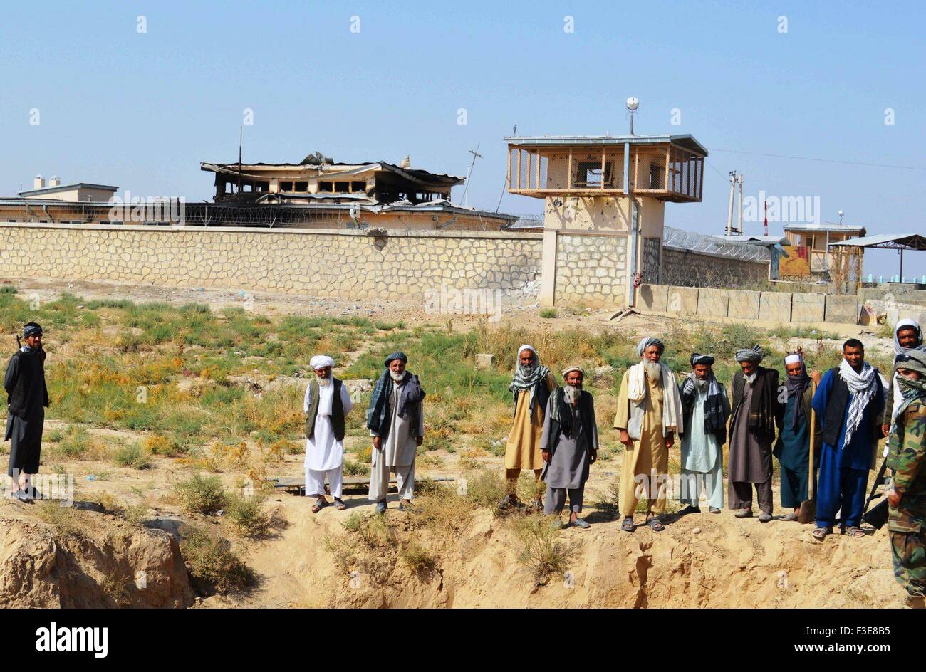 Kunduz, Kunduz province of Afghanistan. 6th Oct, 2015. Local residents gather in front of a government building after Taliban fighters burnt it down in Kunduz city, capital of northern Kunduz province of Afghanistan, Oct. 6, 2015. Afghan security forces after five days of fierce fighting were able to reopen the road linking Baghlan to Kunduz city and sent reinforcement there to bolster government positions against Taliban fighters, police said. Credit:  Ajmal/Xinhua/Alamy Live News Stock Photo