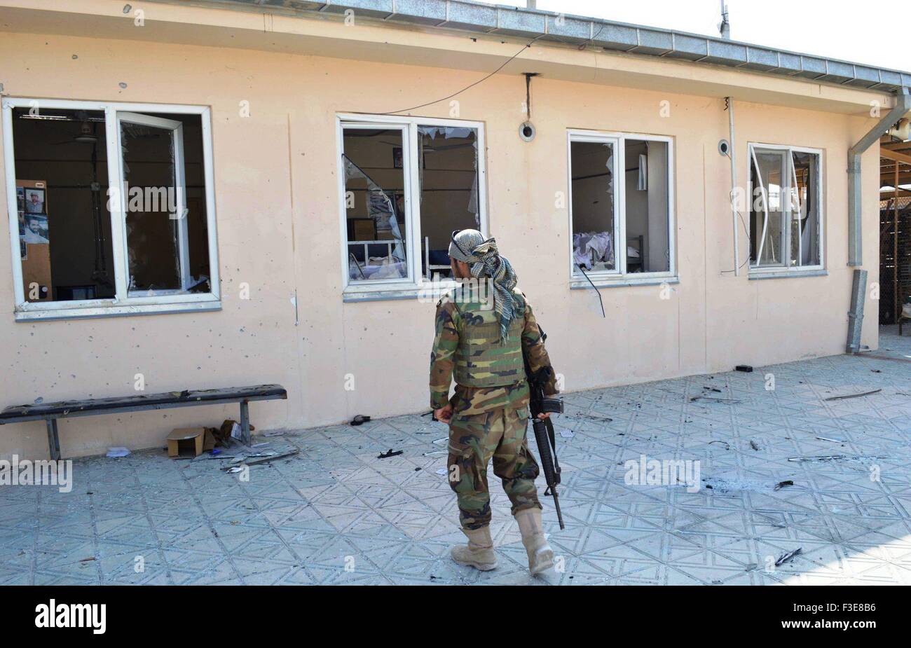 Kunduz, Kunduz province of Afghanistan. 6th Oct, 2015. An Afghan soldier stands as he looks at a government building after Taliban fighters burnt it down in Kunduz city, capital of northern Kunduz province of Afghanistan, Oct. 6, 2015. Afghan security forces after five days of fierce fighting were able to reopen the road linking Baghlan to Kunduz city and sent reinforcement there to bolster government positions against Taliban fighters, police said. Credit:  Ajmal/Xinhua/Alamy Live News Stock Photo