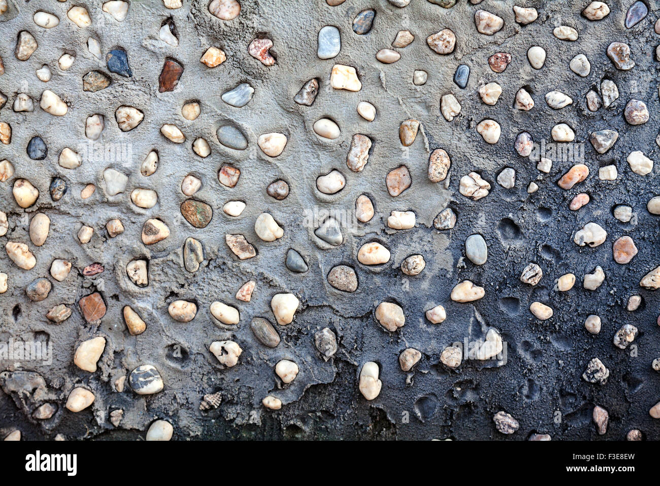 Small pebbles set in concrete wall texture Stock Photo
