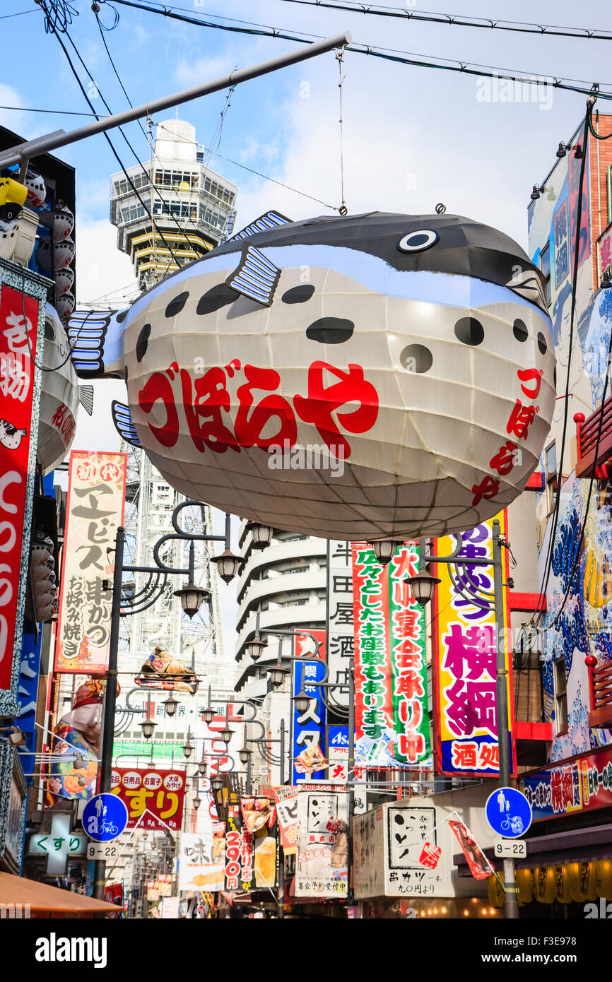 Osaka Shinsekai Landmark And Symbol Of Naniwa Tsutenkaku Tower Towering Over Street With Famous Puffer Fish Sign Outside Zuboraya Restaurant Stock Photo Alamy