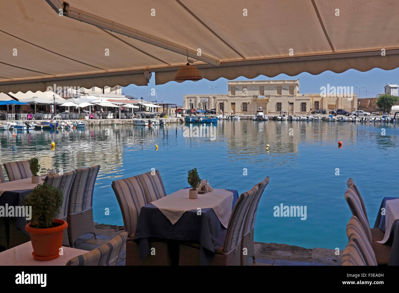 RETHYMNON VENETIAN HARBOUR FROM WITHIN A QUAYSIDE RESTAURANT. CRETE GREEK ISLAND. Stock Photo