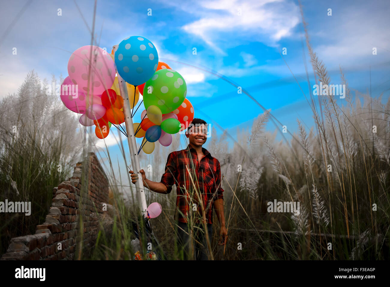 Dhaka, Bangladesh. 6th Oct, 2015. Oct 06, 2015 - Dhaka, Bangladesh - A street vendor smiles with his balloon at Keranigonj, Dhaka. © Mohammad Ponir Hossain/ZUMA Wire/Alamy Live News Stock Photo