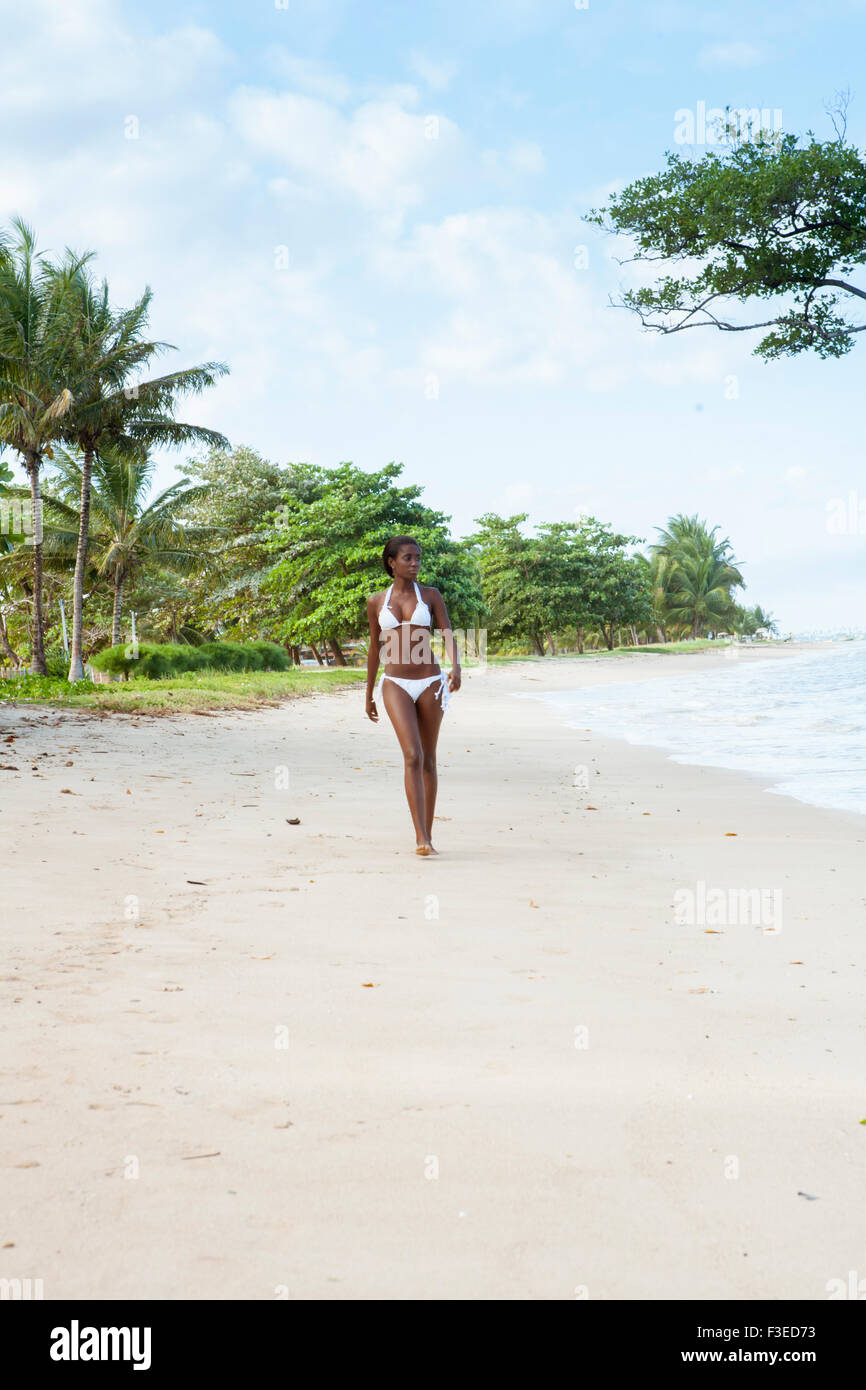An Afro-Brazilian woman walking along the beach on Itaparica island, Bahia Stock Photo