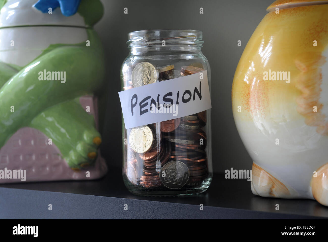 GLASS JAR WITH MONEY AND PENSION SIGN  ON SHELF RE PENSIONS PRIVATE COMPANY SAVERS SAVINGS OLD AGE RETIREMENT PLAN PLANNING UK Stock Photo