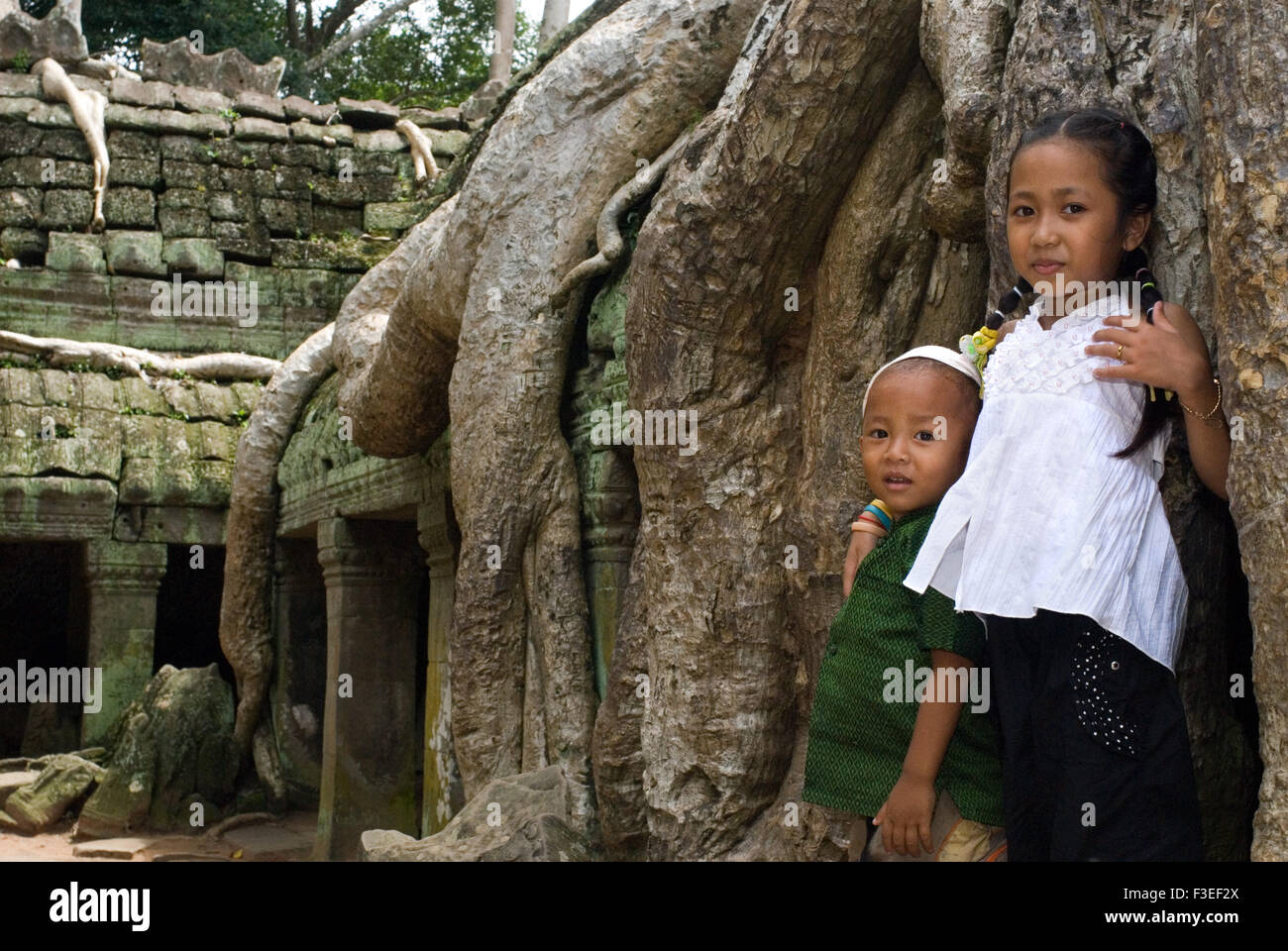 Children playing in the temple of Ta Prohm. Unlike most of the temples of Angkor, Ta Prohm has been largely left to the clutches Stock Photo