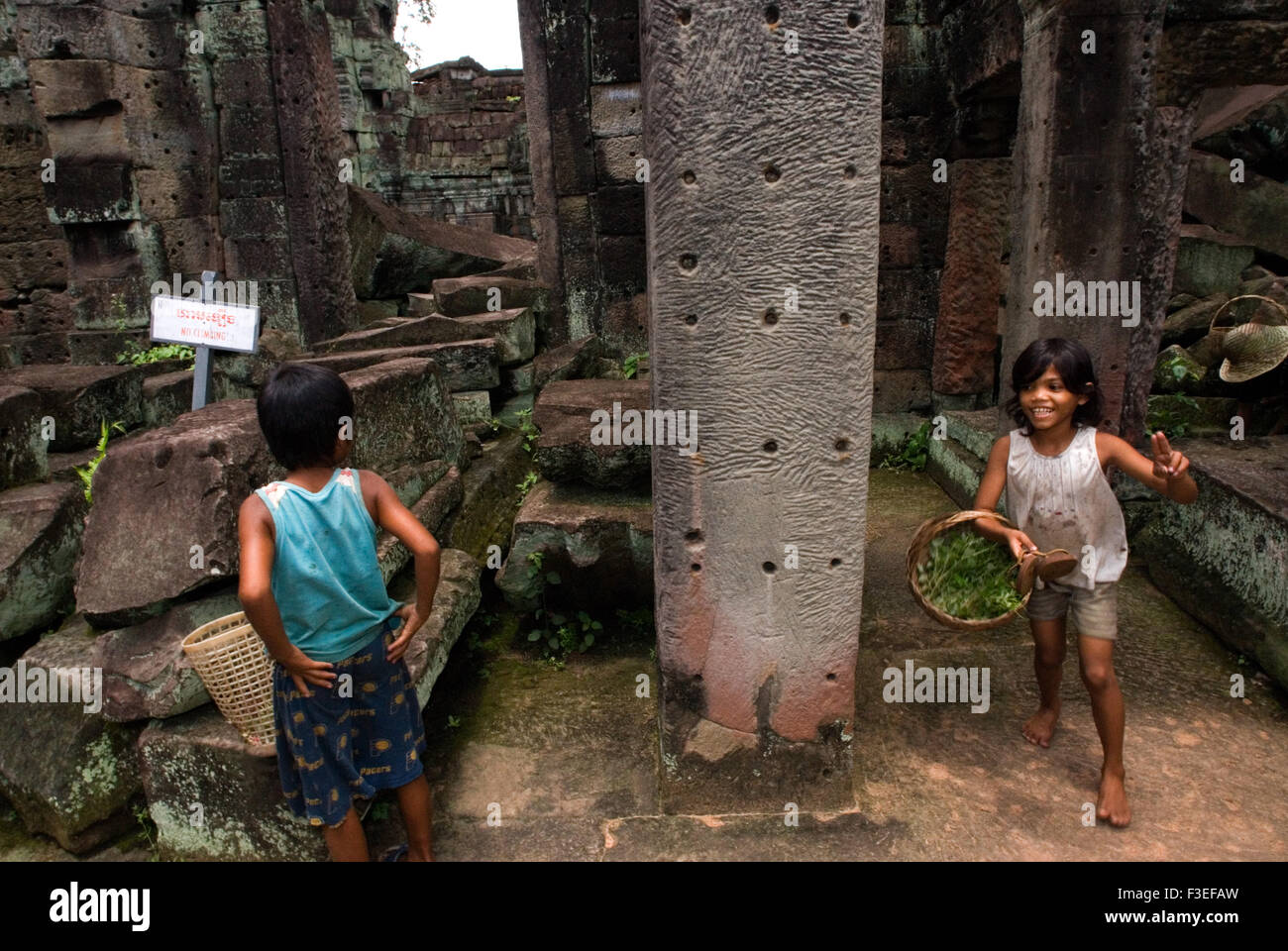 Children playing inside the Preah Khan Temple. In 1191, five year after the building of Ta Prohm, the king dedicated this temple Stock Photo