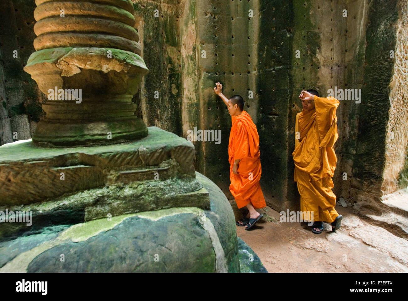 Two Buddhist monks in the inner part of the Temple Preah Khan.  Little is known about the history of Preah Khan. To distinguish Stock Photo
