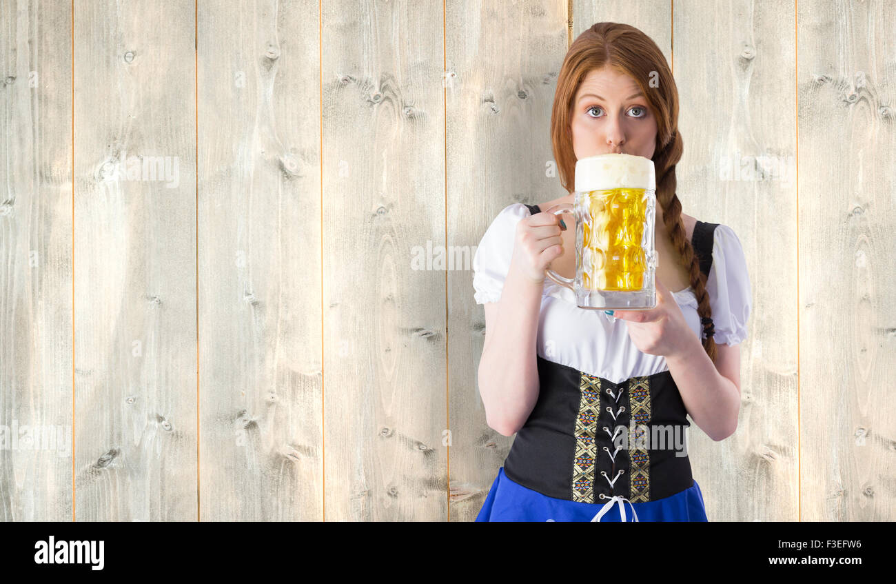 Composite image of oktoberfest girl drinking jug of beer Stock Photo