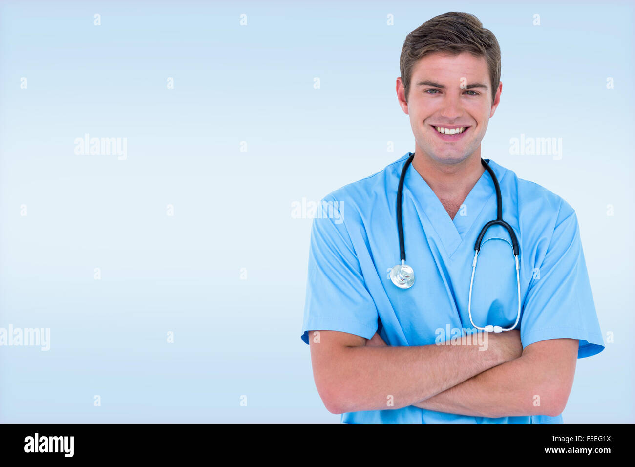Composite image of young nurse in blue tunic with arms crossed Stock Photo