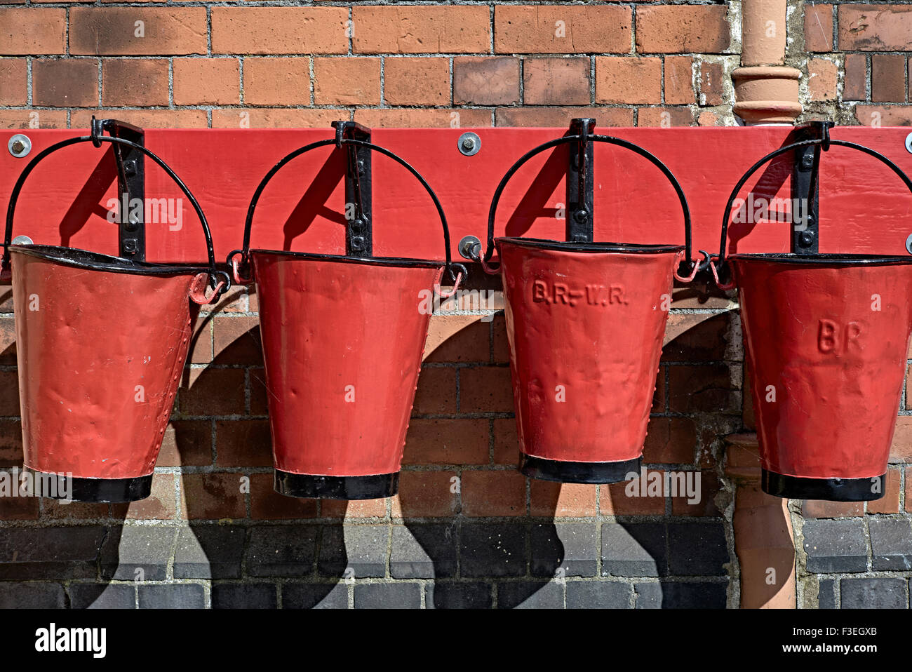 Vintage emergency sand filled red fire buckets displayed at Toddington