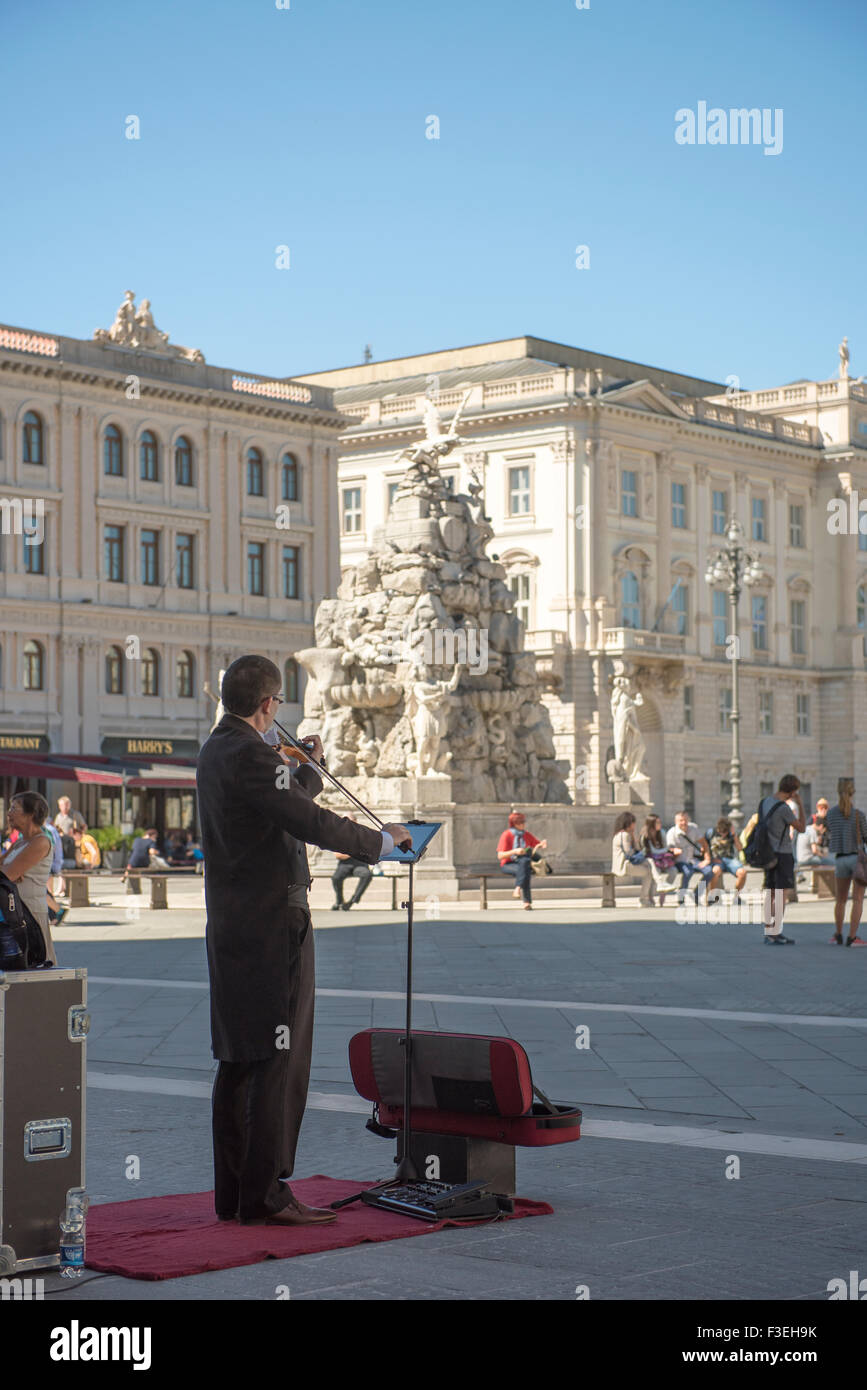 Busker Italy piazza Trieste, A violinist plays his instrument in the Piazza Unita d'Italia in the centre of Trieste, Italy. Stock Photo