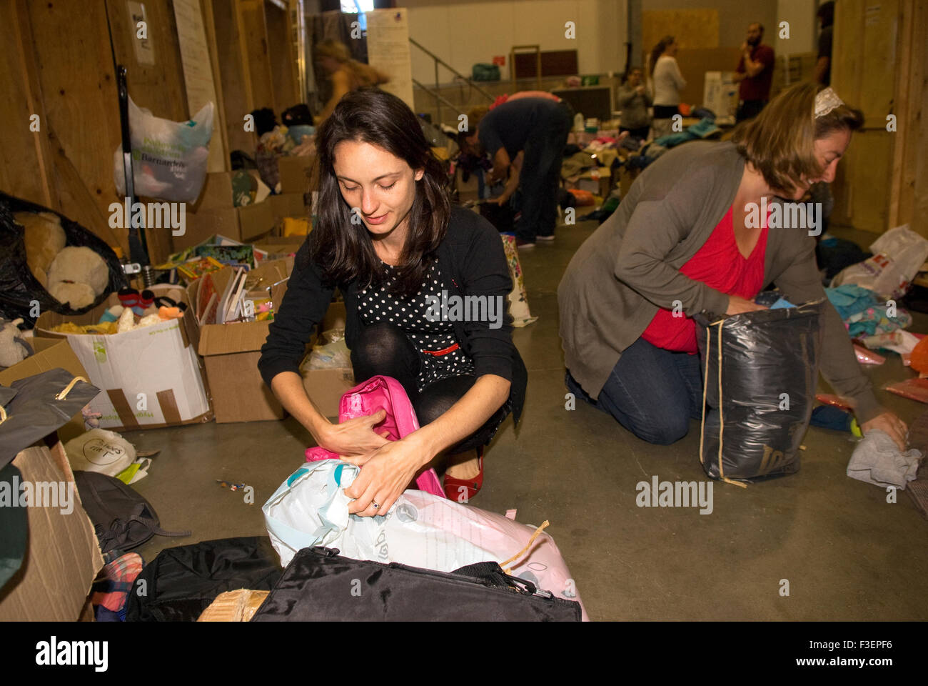 Volunteers in a shipping company's warehouse packing up donated items