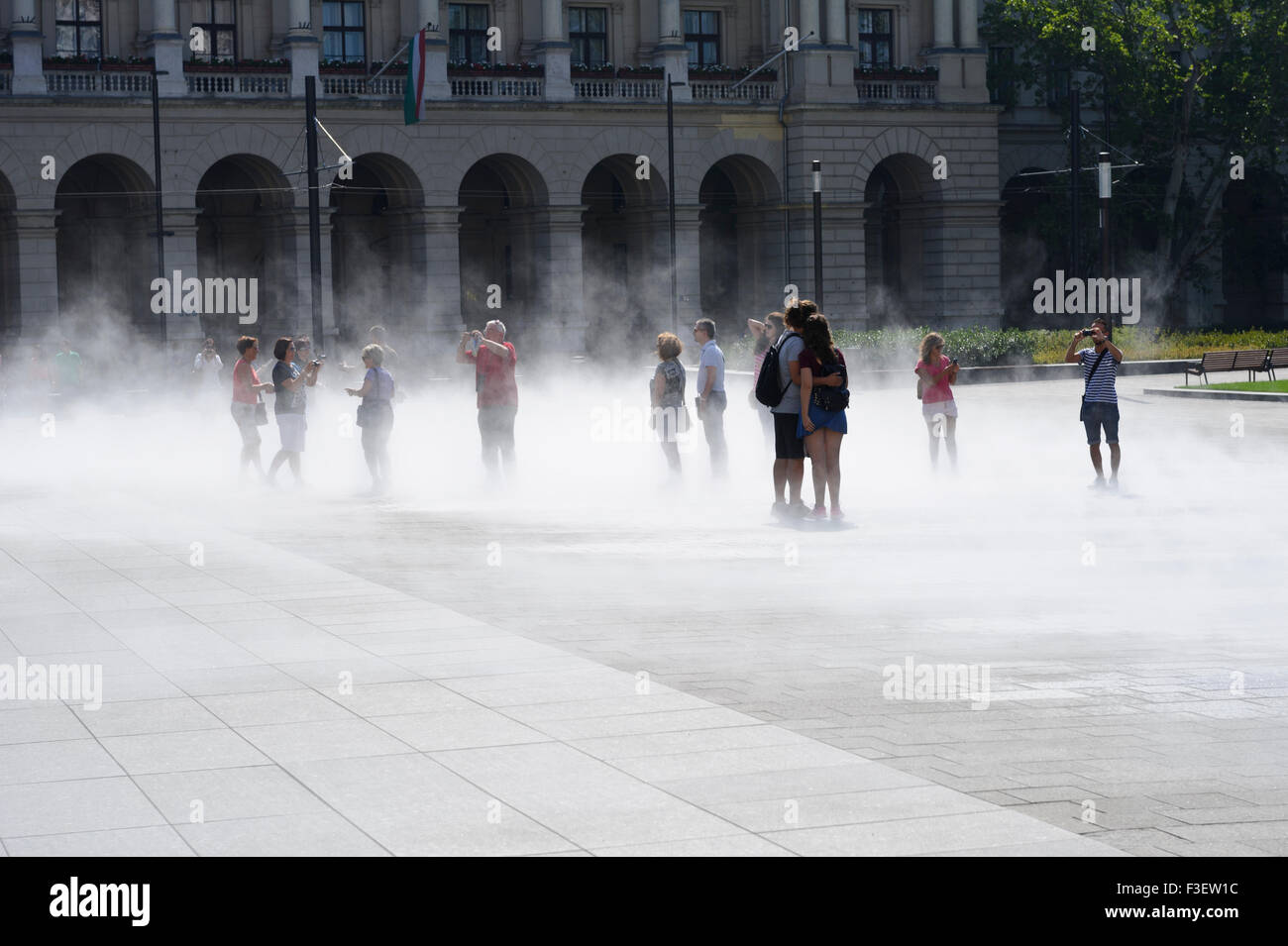 Cold steam coming out of the ground where people are standing in front of the Hungarian Parliament, Budapest, Hungary. Stock Photo