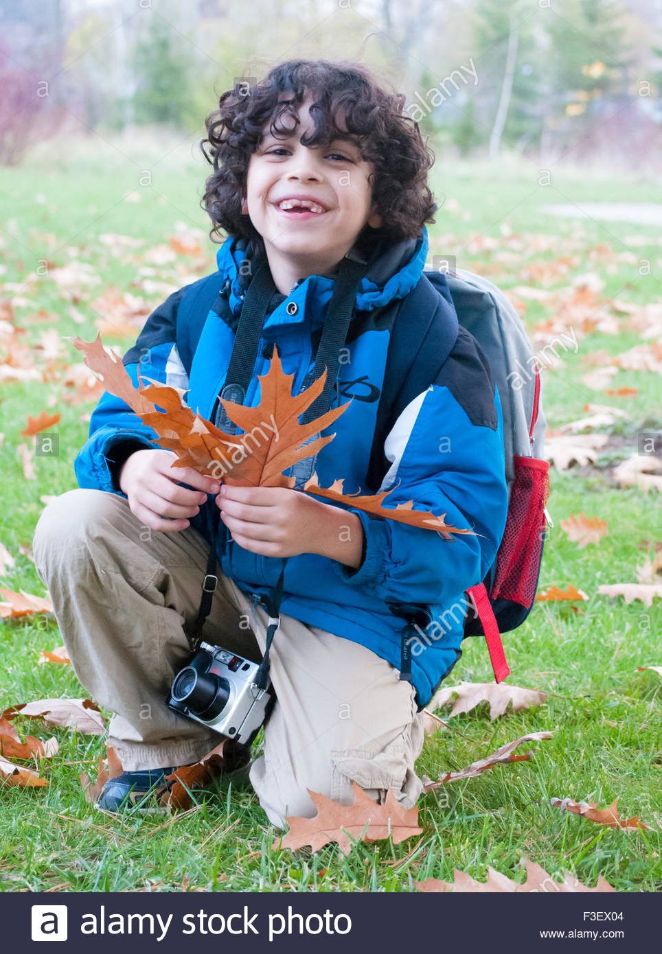 Boy With A Camera During Autumn Or Fall He Has Dark Curly
