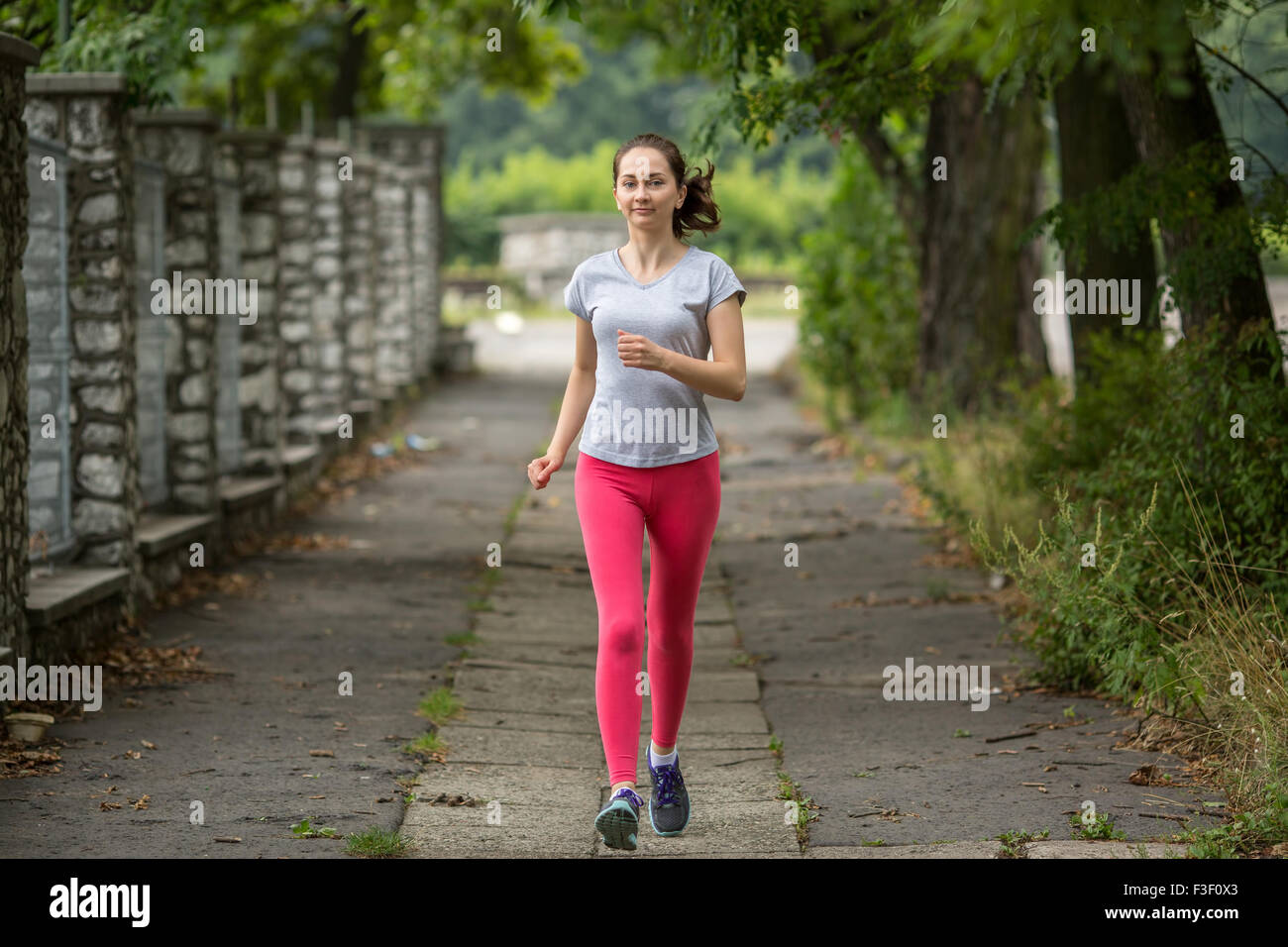 Young sports girl during a jog in the Park. Running, healthy lifestyle. Stock Photo