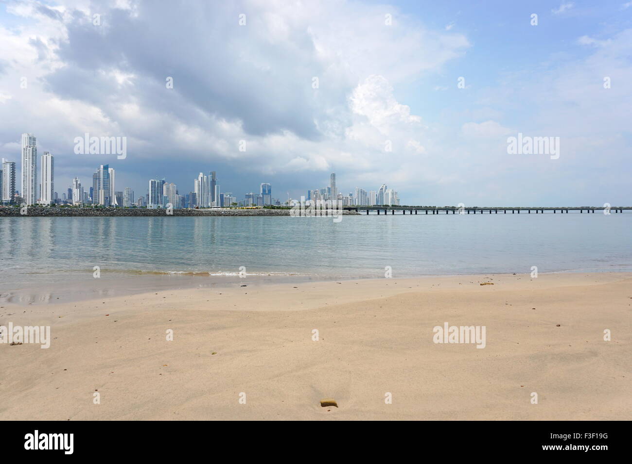 Sandy beach with the new highway over the bay and the skyscrapers of Panama city in background, Panama, Central America Stock Photo