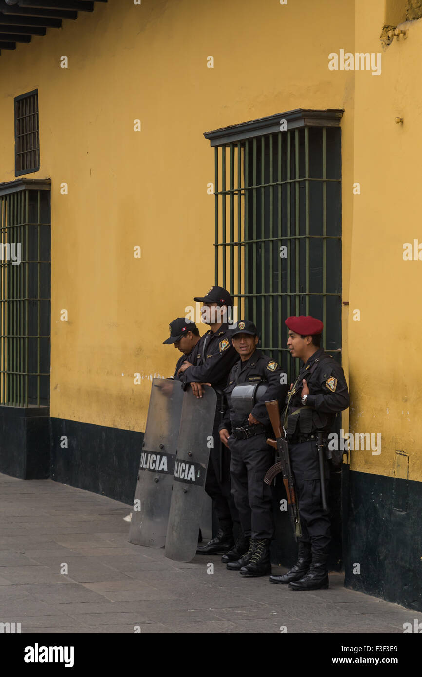 Lima, Peru - September 02, 2015: Four policemen are guarding a side road to the central square in front of the government palace Stock Photo