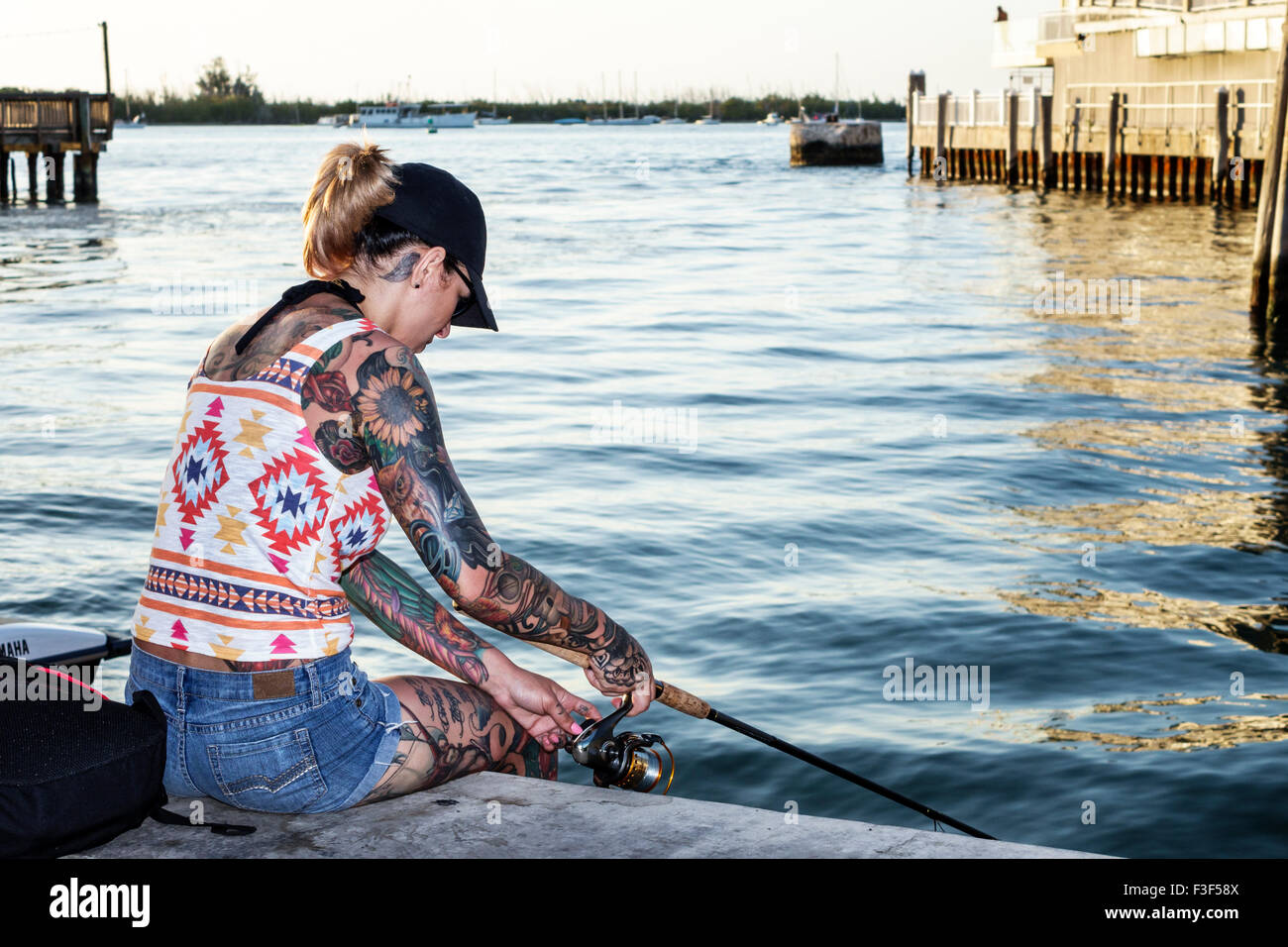 Key West Florida,Keys Sunset Pier,woman female women,tattoos,fishing,Gulf of Mexico,FL150508059 Stock Photo