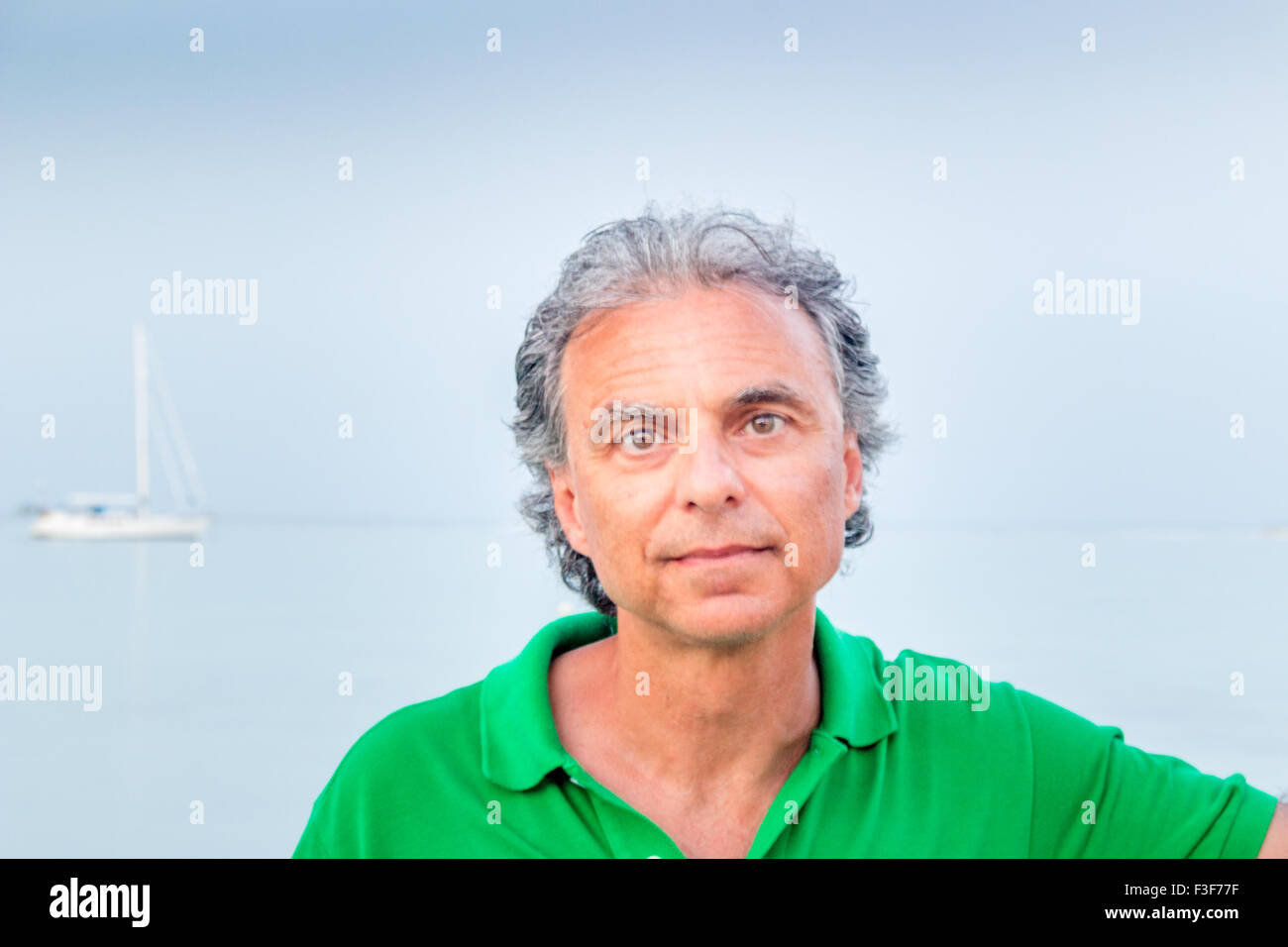 charming middle-aged man in green polo in a seaside town Stock Photo