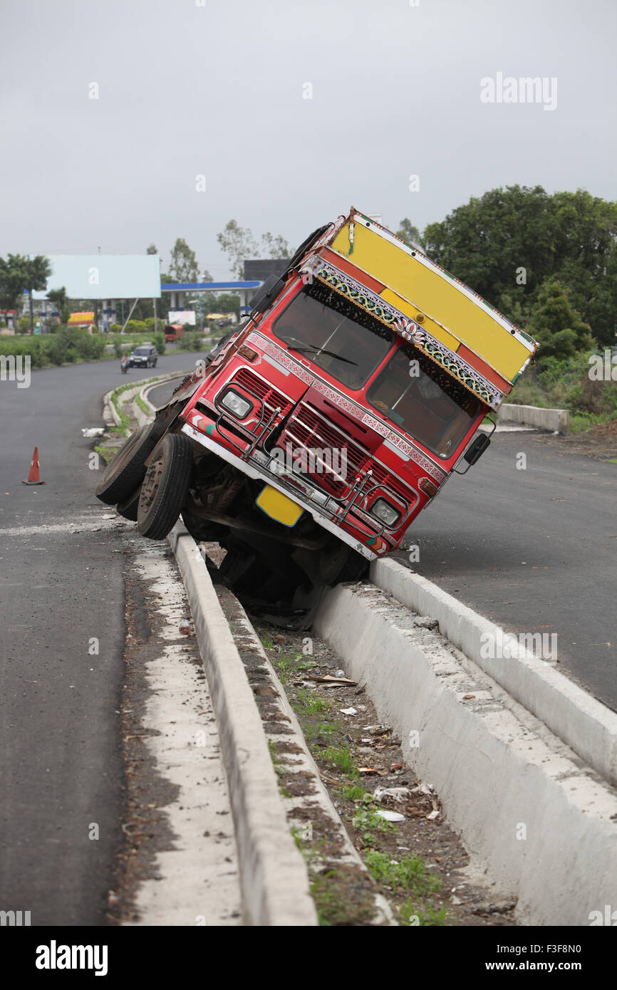An accident of a truck stuck in the rainwater drain passage on an Indian highway Stock Photo