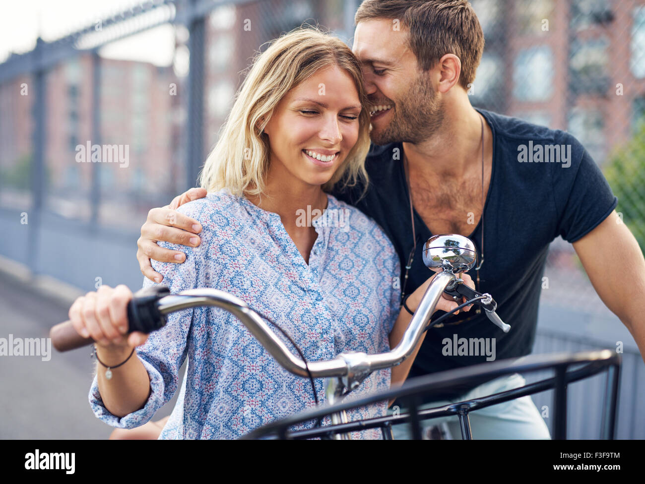 City couple loving each other while out riding bikes Stock Photo