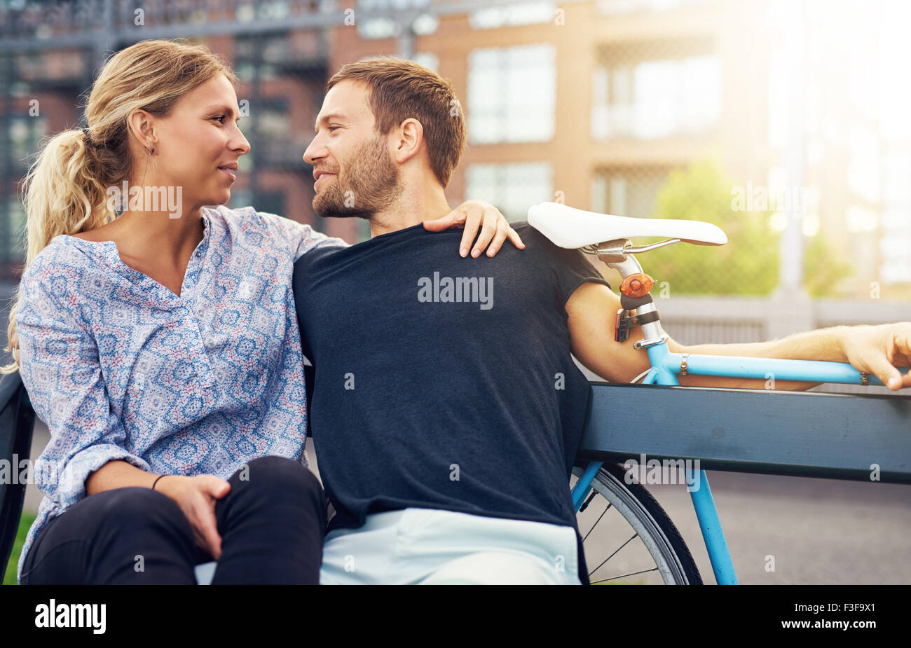 Loving couple sitting on bench in a city environment Stock Photo