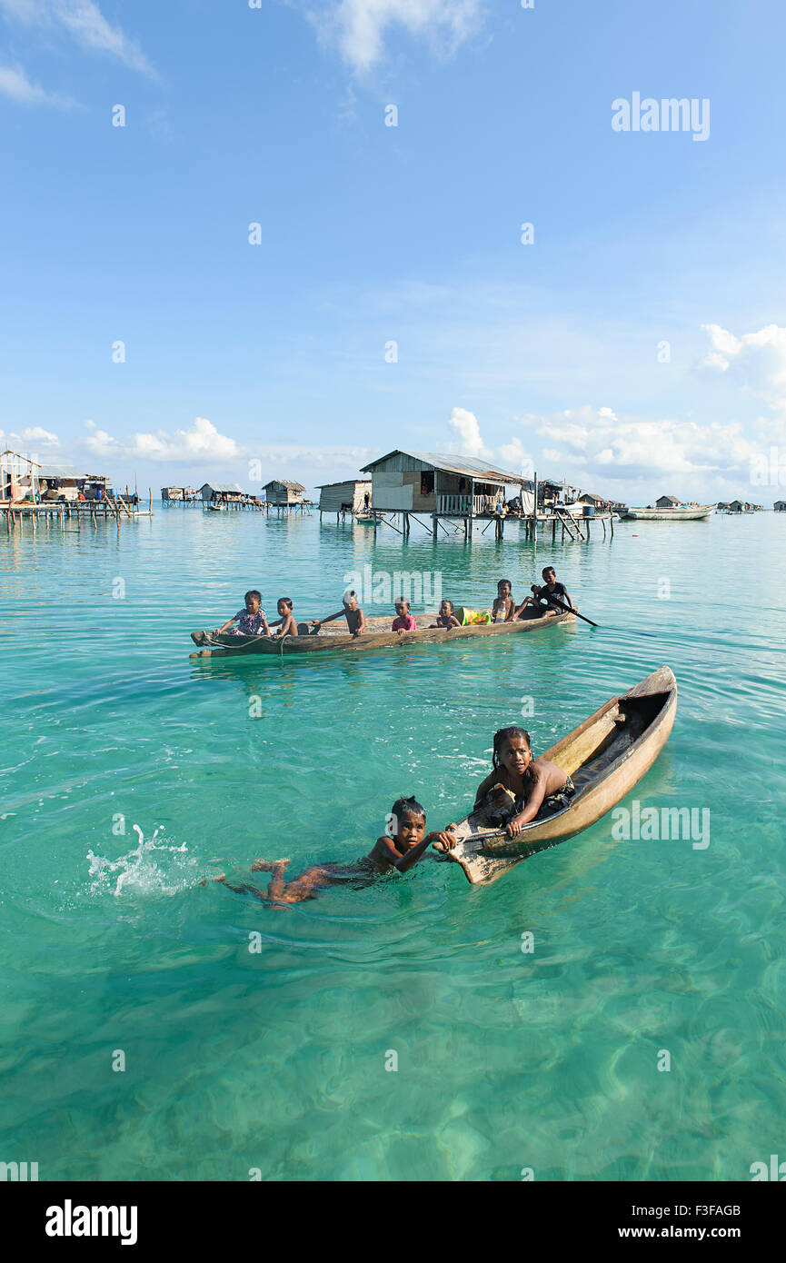 Unidentified Borneo Sea Gypsy kids on a canoes  in Mabul Maiga Island, Sabah Borneo, Malaysia. Stock Photo