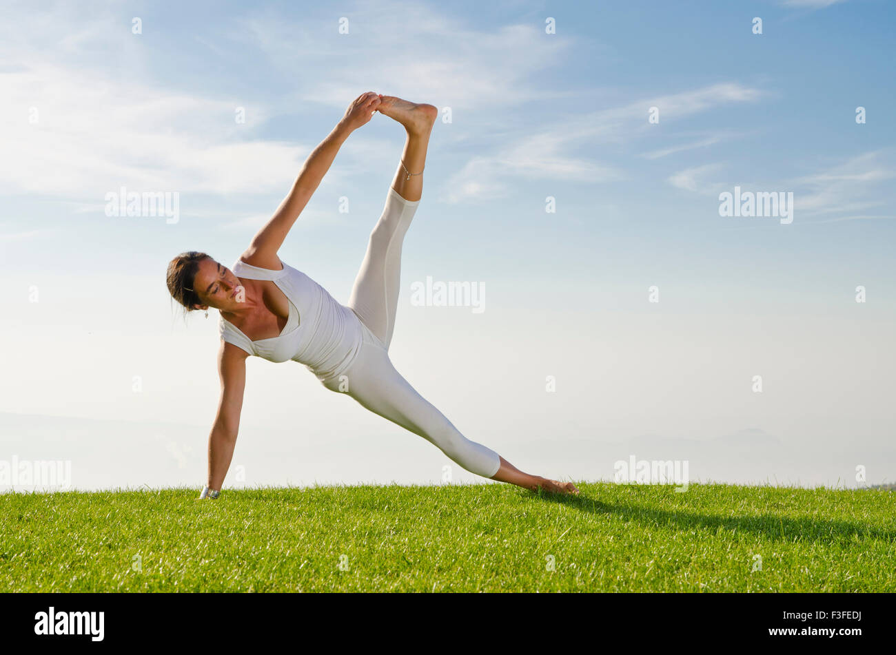 Young woman practising Hatha-Yoga outdoor, showing the pose  vasishthasana,  sage vashishta's pose Stock Photo