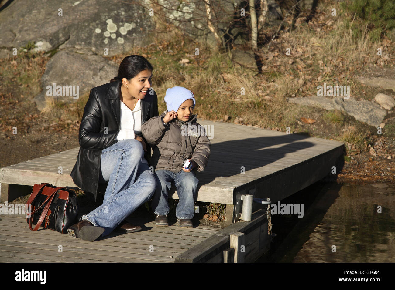 Mother and four years old son sitting near lake ; Sweden ; Scandinavia MR#468 Stock Photo