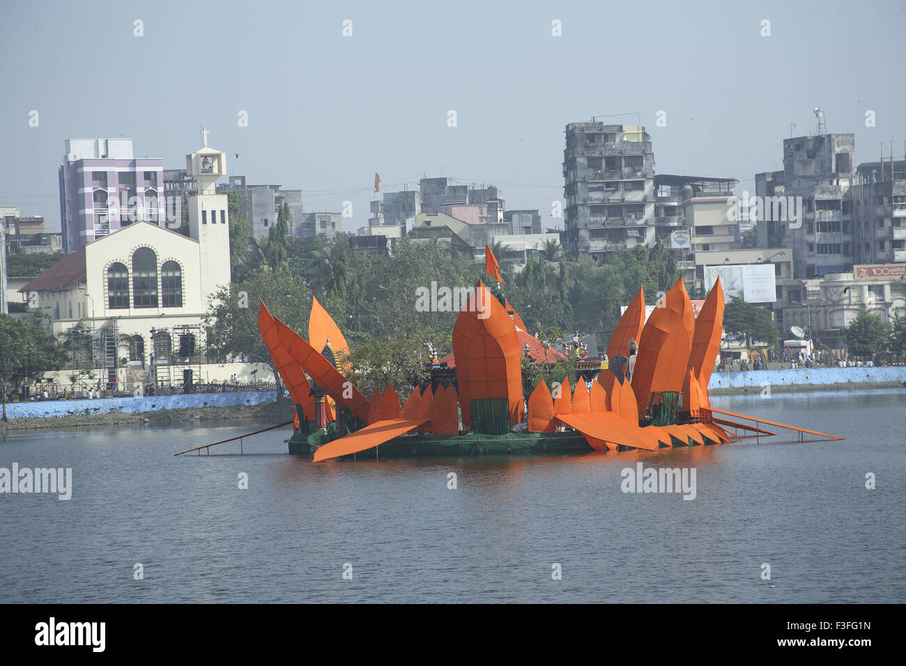 Man made Orange colored Lotus surrounding Mahadev Mandir Masunda Lake Saint John Baptist Church Festival Thane Maharashtra Stock Photo