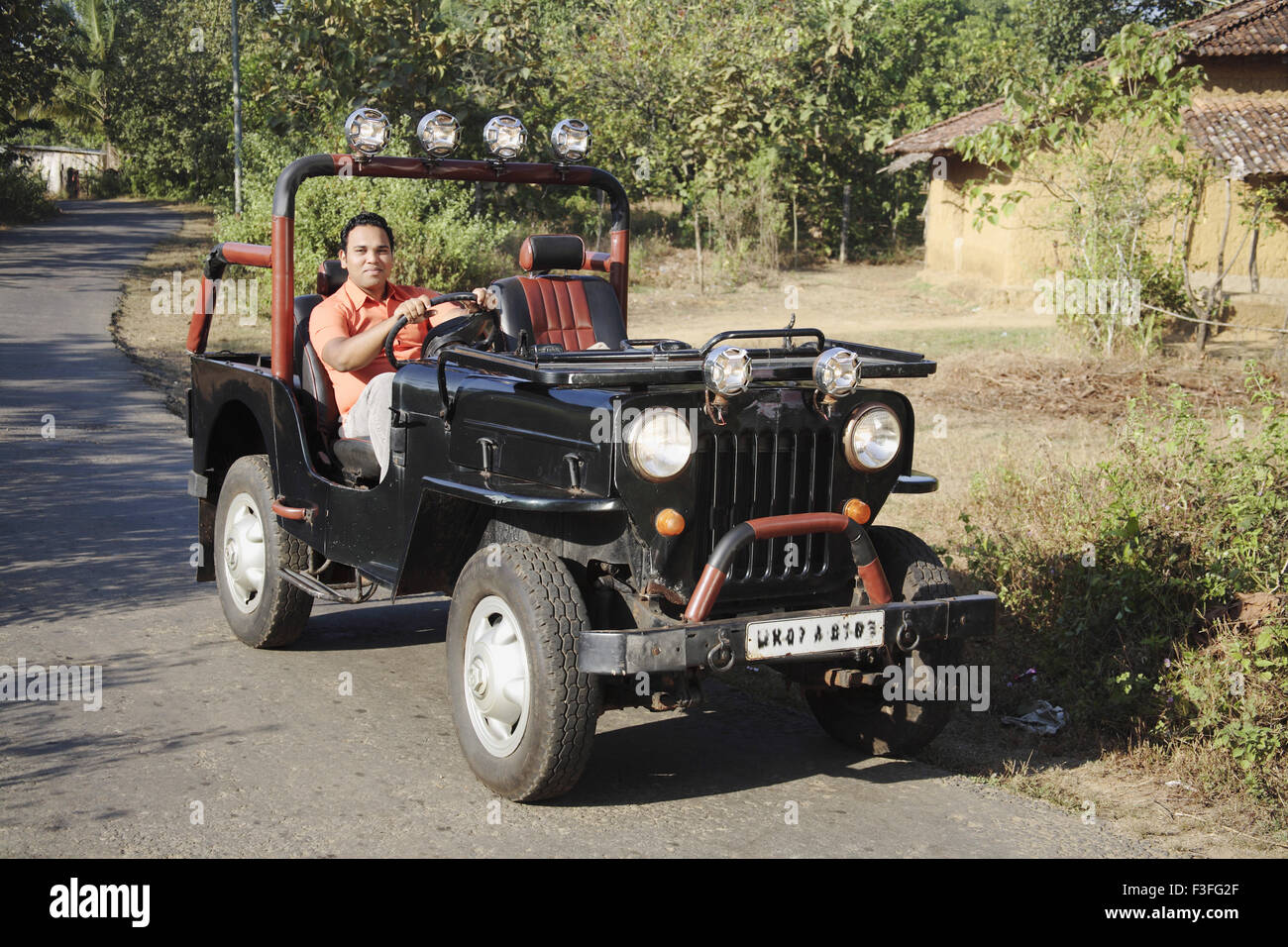 South Asian Indian young man sitting on driver's seat in India jeep and holding steering wheel ; India MR# 703H Stock Photo