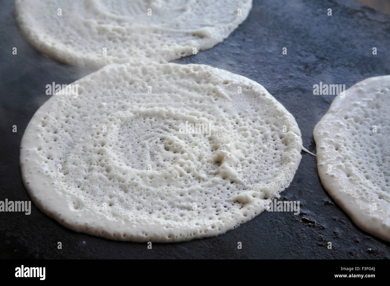 Dosa preparation ; Dosa on hot plate ; South Indian bread Stock Photo
