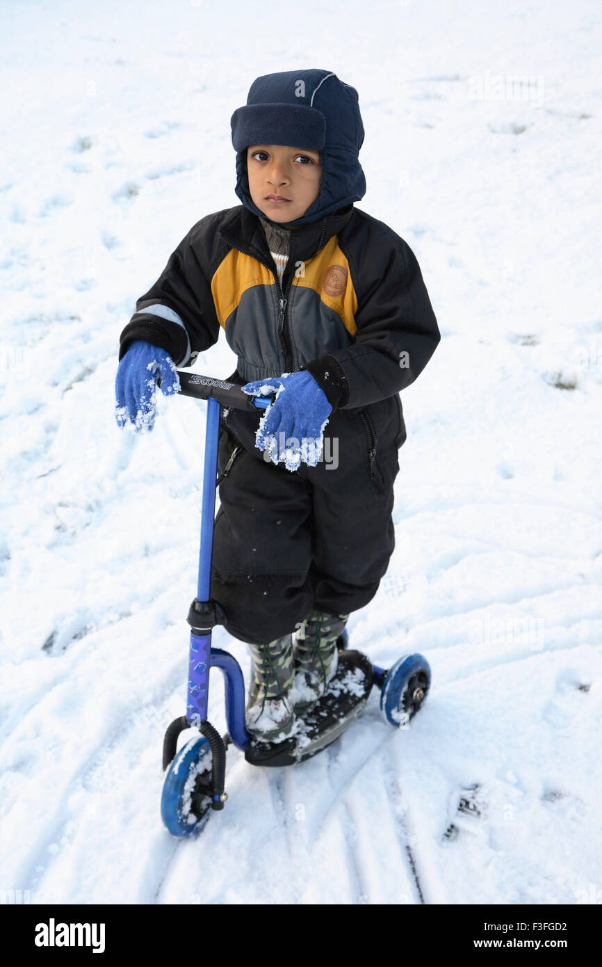 Small boy riding his tri wheel on snow ; Sweden MR#468 Stock Photo