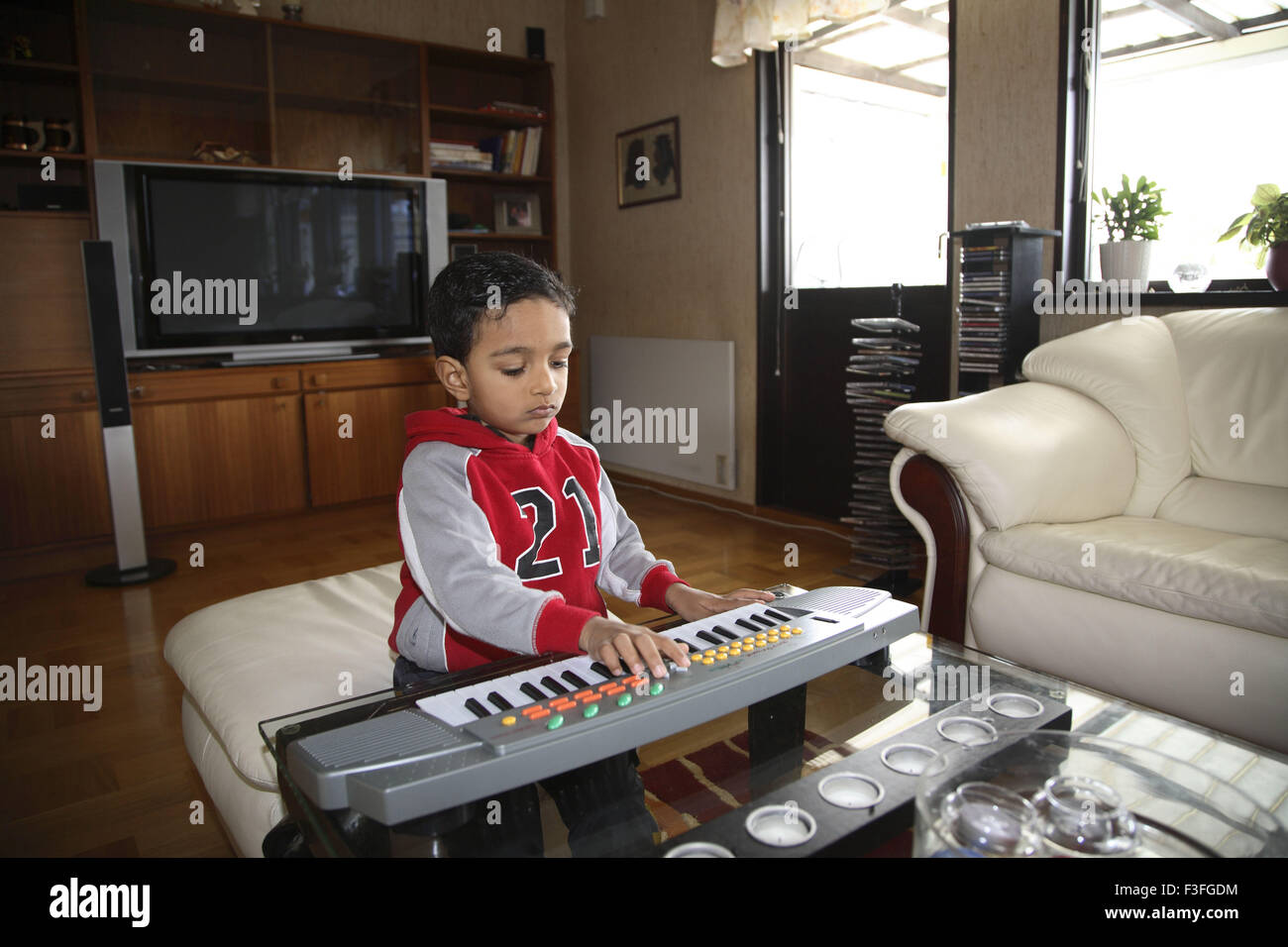 Four years old boy playing with mini toy keyboard ; Sweden PR#703L ; MR#468 Stock Photo