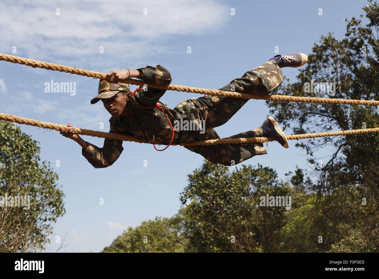 Commando Obstacles training ; cadet crossing the distance by crawling on rope ; Military school ; Amboli Sindhudurga Stock Photo