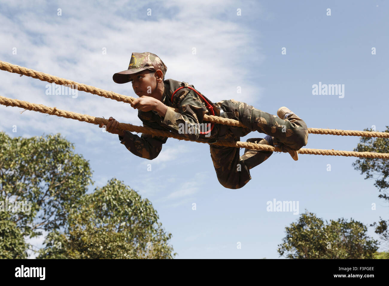 Commando Obstacles training ; cadet crossing the distance by crawling on rope ; Military school ; Amboli Sindhudurga Stock Photo