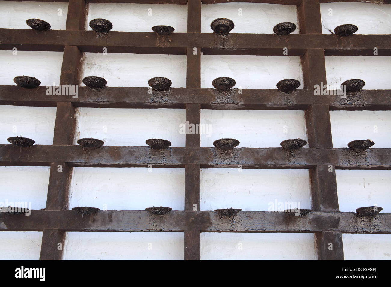 Small oil lamps lining on outer wall of temple at Kodulgalloor ; Kerala ; India Stock Photo