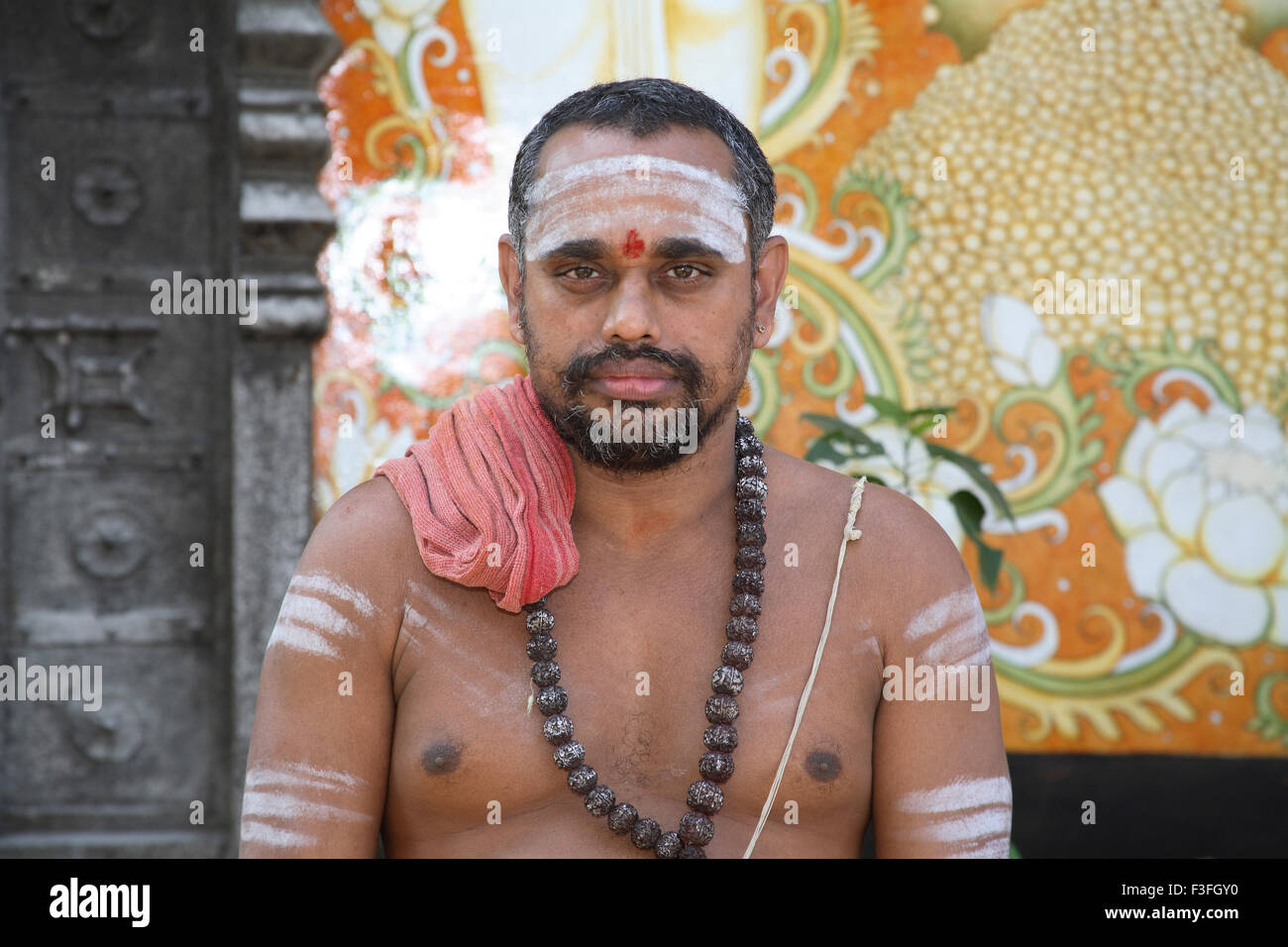 Religious preacher wearing rudraksha mala applying holy ash bhasma body