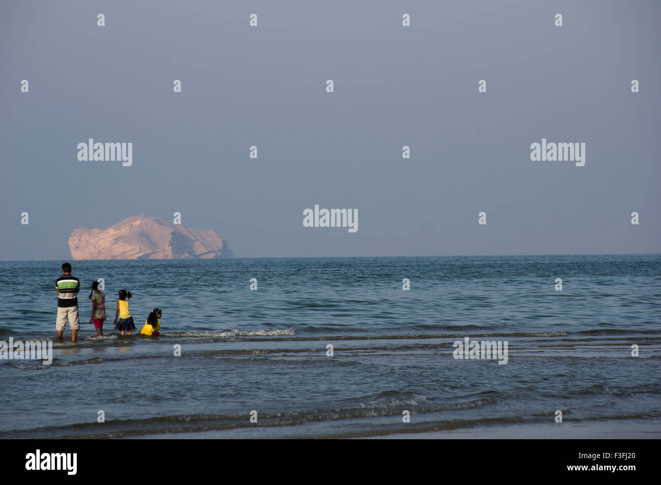 A family looks out across the Gulf of Oman in Muscat in the Sultanate of Oman, a safe, friendly Gulf State holiday destination Stock Photo