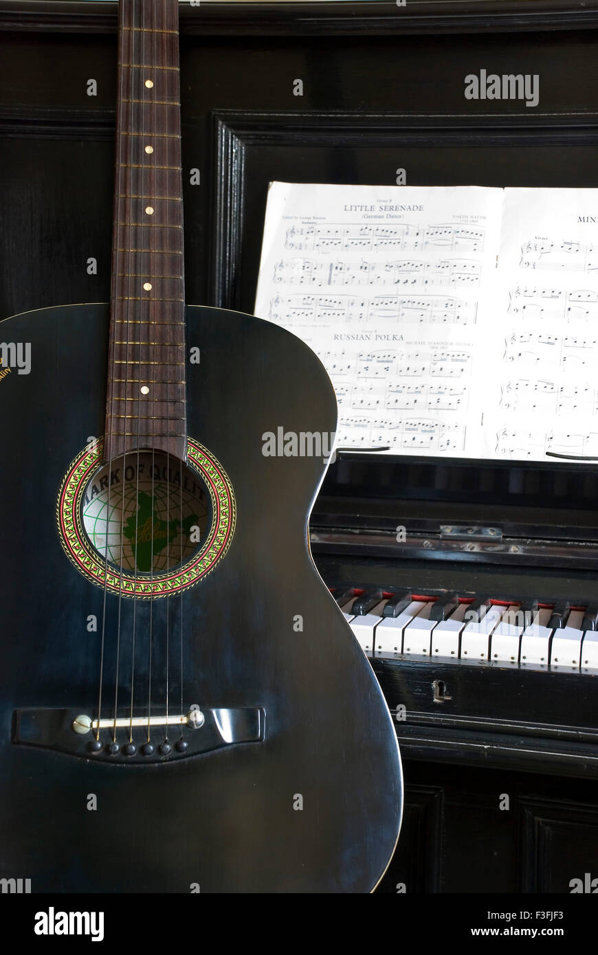 Musical Instruments ; Spanish Guitar and an upright Piano Stock Photo