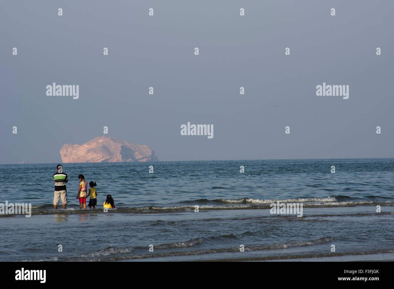A family looks out across the Gulf of Oman in Muscat in the Sultanate of Oman, a safe, friendly Gulf State holiday destination Stock Photo