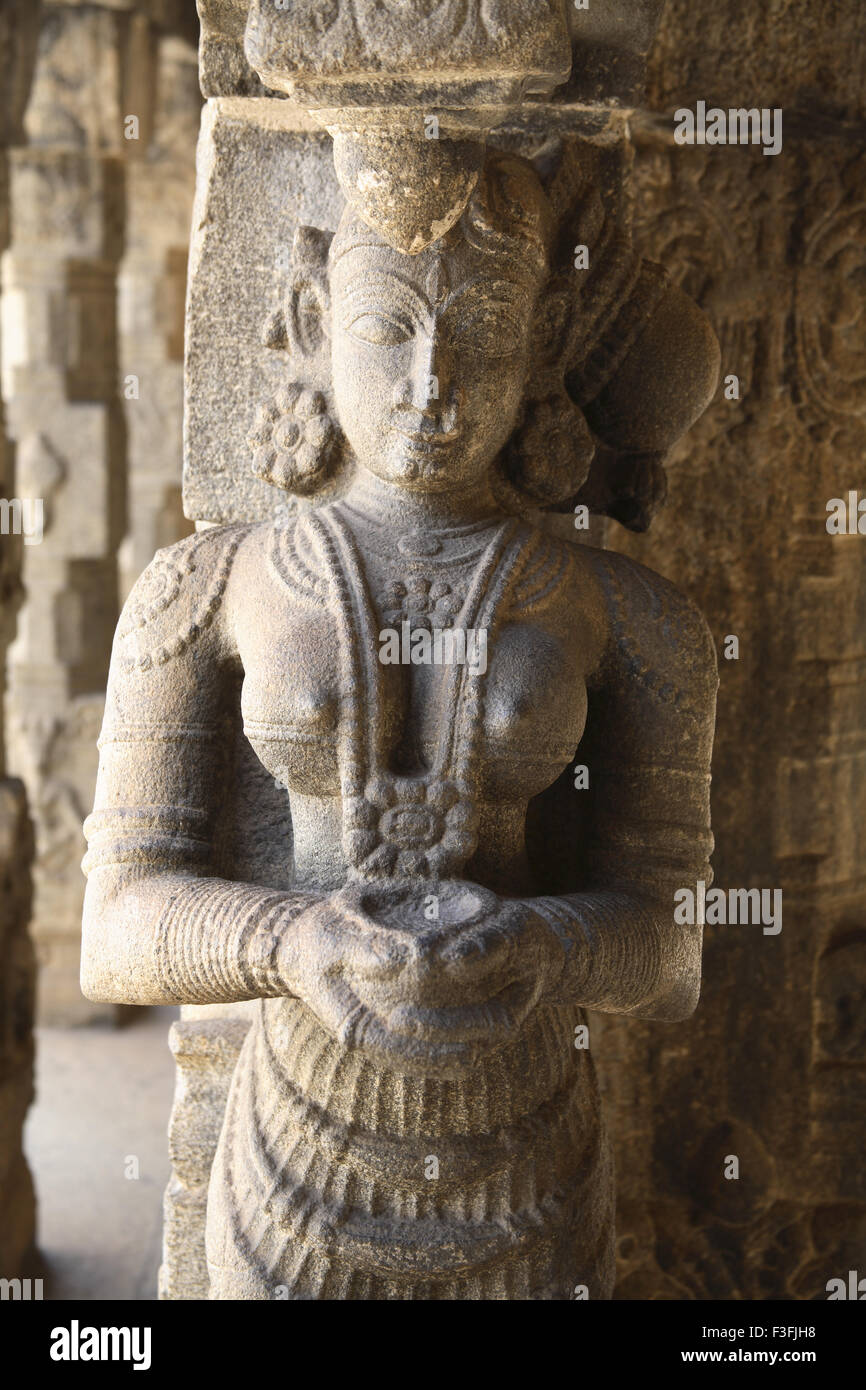 Carved figurines carrying lamps ; Carving pillars Nataksala solid granite pillars Padmanabhapuram Wood Palace Tamil Nadu Stock Photo