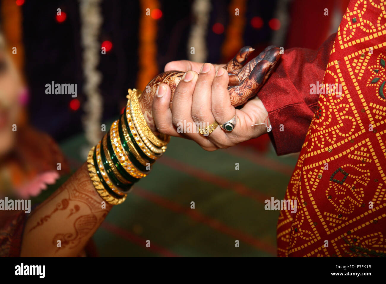 Bridegroom holding hand of bride performing ritual vidhi in maharashtrian wedding ceremony Stock Photo